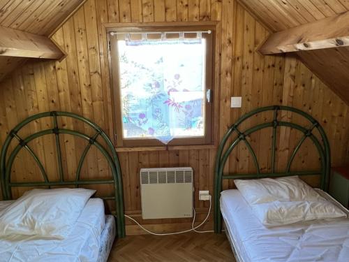 two beds in a room with a window at Chalet Cabourg, 4 pièces, 6 personnes - FR-1-487-214 in Cabourg