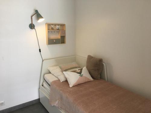 a small room with a bed and a lamp at Studio Merville-Franceville-Plage, 1 pièce, 3 personnes - FR-1-487-222 in Merville-Franceville-Plage