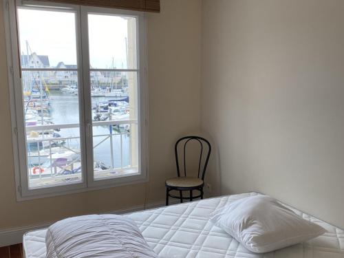 - une chambre avec un lit et une fenêtre avec un port de plaisance dans l'établissement Appartement 3 pièces calme avec ascenseur à Dives-sur-Mer - FR-1-487-319, à Dives-sur-Mer
