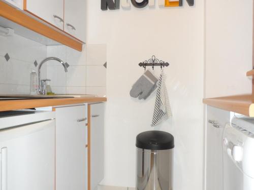 une cuisine avec des placards blancs et un tabouret noir dans l'établissement Cottage 3 Pièces Avec Jardin Privatif Sud, Parking, Piscine - Proche Port Guillaume - FR-1-487-320, à Dives-sur-Mer