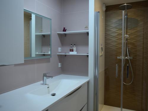 une salle de bain blanche avec un lavabo et une douche dans l'établissement Appartement lumineux avec grande terrasse, fibre et garage - FR-1-197-522, à Les Sables-dʼOlonne