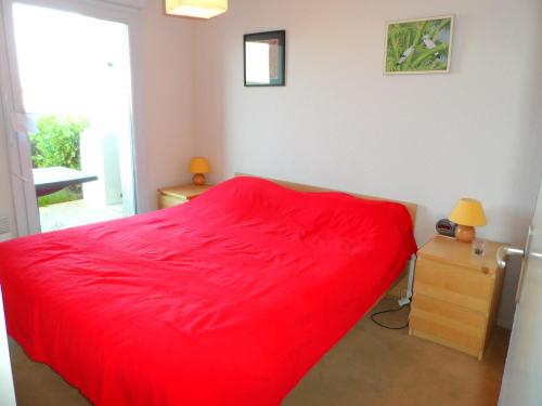 - un lit rouge dans une chambre avec fenêtre dans l'établissement Duplex 4 pièces avec piscine, jardin et parking à Dives-sur-Mer - FR-1-487-282, à Dives-sur-Mer