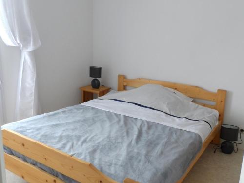 a bedroom with a bed with a wooden frame at Appartement 2 pièces avec piscine et parking à Dives-sur-Mer - FR-1-487-294 in Dives-sur-Mer