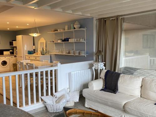 un salon avec un canapé blanc et une cuisine dans l'établissement Grand Duplex en Front de Mer avec 3 Chambres, Animaux Acceptés, Equipements Complets, Cabourg - FR-1-487-321, à Cabourg
