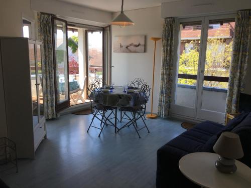 un salon avec une table, des chaises et un canapé dans l'établissement Grand studio en hyper-centre de Cabourg avec balcon, proche plage, parking, et prestations disponibles - FR-1-487-327, à Cabourg