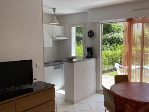 une cuisine avec une table, une télévision et une salle à manger dans l'établissement Cabourg : Studio Rez-de-Jardin Proche Plage, Animaux Acceptés, TV, Wi-Fi Optionnel - FR-1-487-331, à Cabourg