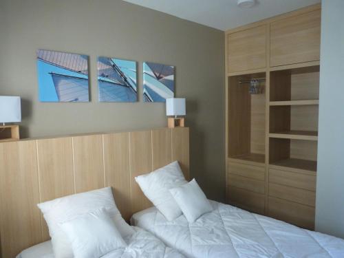 a bedroom with a bed with white sheets and pillows at Appartement luxe 2 chambres, balcon, accès plage, piscine, animaux admis, parking - FR-1-194-236 in La Tranche-sur-Mer