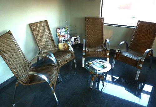 three wicker chairs and a table in a room at Turis Hotel in Dourados