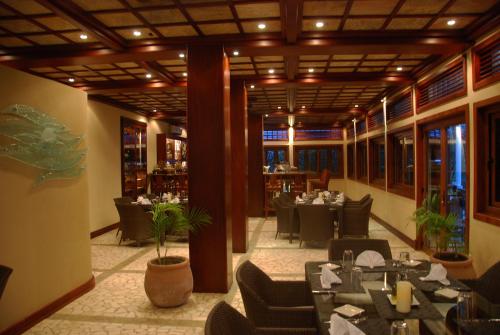 a dining room with tables and chairs in a restaurant at Placencia Resort in Maya Beach