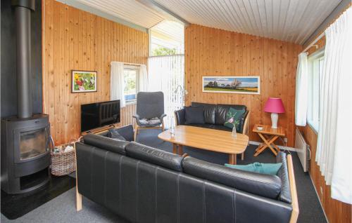 a living room with a leather couch and a fireplace at Cozy Home In Samsø With Sauna in Onsbjerg