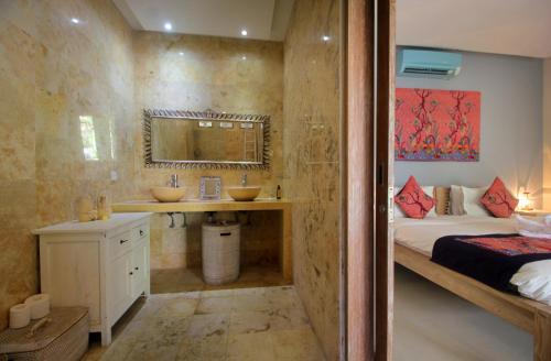 a bathroom with a bed and a sink in a room at Villa Ananda by Optimum Bali Villas in Seminyak