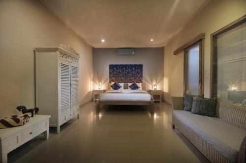 a large bedroom with a bed and a couch at Villa Ananda by Optimum Bali Villas in Seminyak