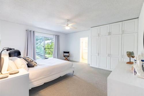 Un dormitorio blanco con una cama y una ventana. en 2 26 Voyager Cl waterfront ground floor unit, en Nelson Bay
