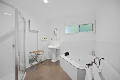 a white bathroom with a tub and a sink at Amelina Cottages in Marysville