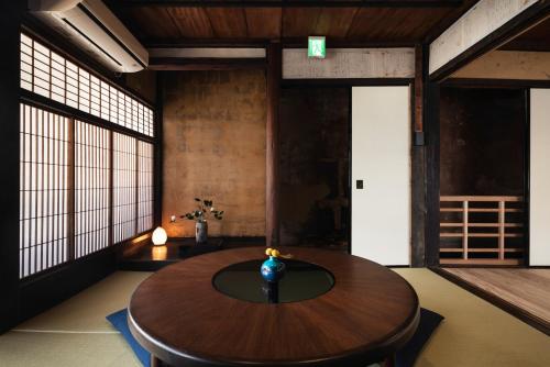 a room with a wooden table with a vase on it at Nipponia 甲佐 疏水の郷 in Kosa