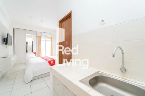 a white kitchen with a sink and a mirror at RedLiving Apartemen JP Bogor - Fix Room in Kedungbadak