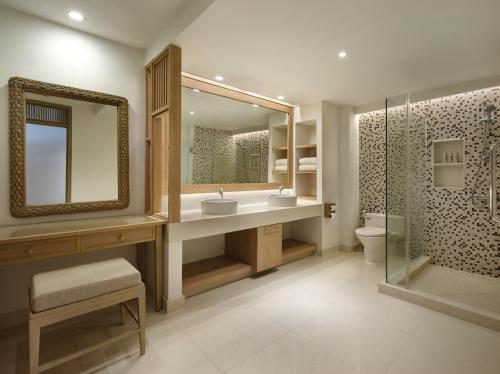 a bathroom with a sink and a mirror and a toilet at Garrya Tongsai Bay Samui in Choeng Mon Beach