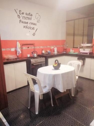 uma cozinha com uma mesa e cadeiras brancas e uma mesa e uma mesa e cadeiras em Apartamento familiar em Trujillo