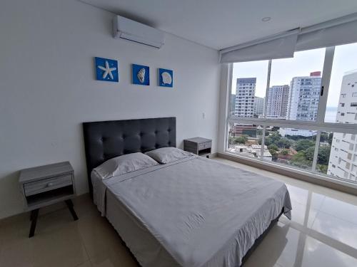 a bedroom with a bed and a large window at Resort de Reserva del Mar in Santa Marta