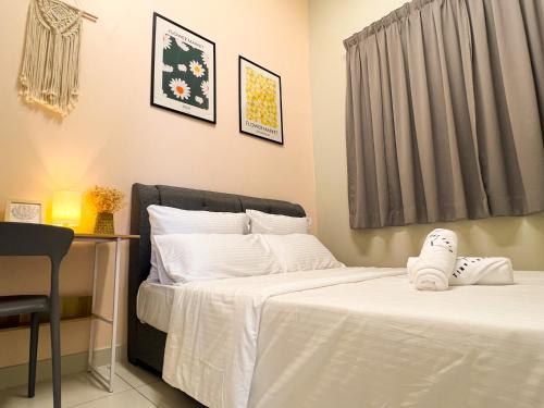 a bedroom with two beds with white sheets and shoes at Skypod Residence Puchong in Puchong