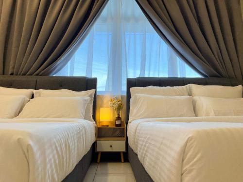 two beds in a bedroom with a window at Skypod Residence Puchong in Puchong