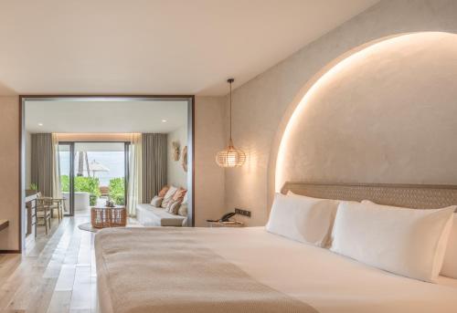 a bedroom with a large bed and a living room at VALA Hua Hin - Nu Chapter Hotels in Cha Am