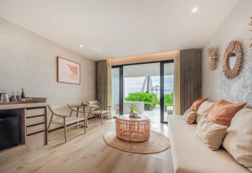 a living room with a white couch and a table at VALA Hua Hin - Nu Chapter Hotels in Cha Am