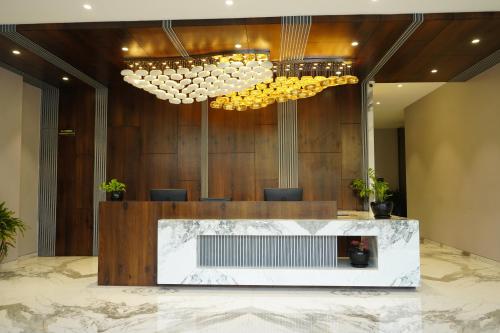 a lobby with a fireplace and chandeliers at Alaukik Hotel in Shirdi