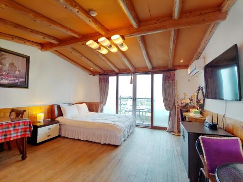 a bedroom with a bed and a large window at Herb in Pension in Jeju