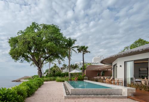 a villa with a swimming pool and a house at VALA Hua Hin - Nu Chapter Hotels in Cha Am