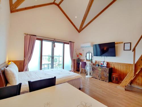 a hotel room with a bed and a tv at Herb in Pension in Jeju