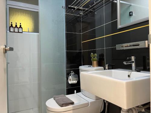 a bathroom with a white sink and a toilet at Skypod Residence Puchong in Puchong