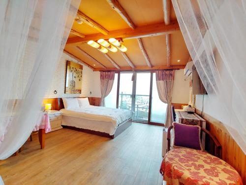 a hotel room with two beds and a chair at Herb in Pension in Jeju