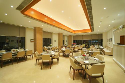 a restaurant with tables and chairs in a room at Pride Hotel Udaipur in Udaipur