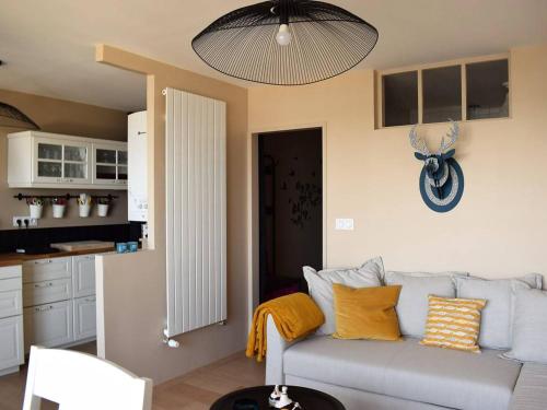 un salon avec un canapé et une cuisine dans l'établissement Appartement rénové à Trégastel avec vue sur mer et parking - FR-1-368-117, à Trégastel