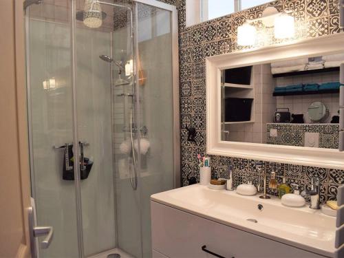 une salle de bain avec une douche, un lavabo et un miroir dans l'établissement Appartement rénové à Trégastel avec vue sur mer et parking - FR-1-368-117, à Trégastel