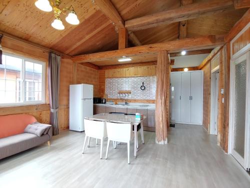 una cucina con un tavolo e sedie in una stanza di Geumok Log Pension a Seogwipo