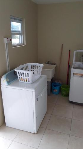 a laundry room with a washing machine and a sink at HARMONY LA VISTA in Runaway Bay