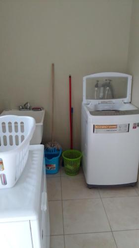 a kitchen with a sink and a washing machine at HARMONY LA VISTA in Runaway Bay