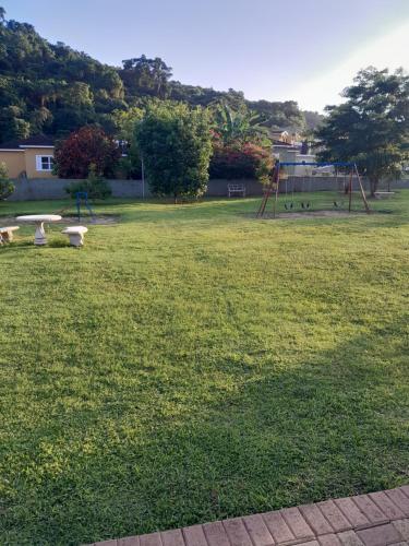 a grassy field with a park with a playground at HARMONY LA VISTA in Runaway Bay