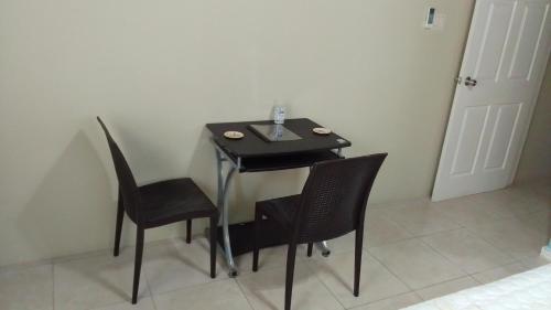 a dining room table with two chairs and a black table at HARMONY LA VISTA in Runaway Bay