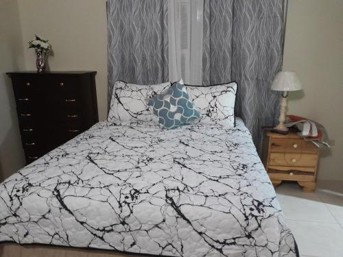 a bedroom with a bed with a black and white comforter at HARMONY LA VISTA in Runaway Bay