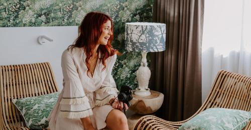 a woman sitting on a chair next to a lamp at Pacific Hotel Cairns in Cairns