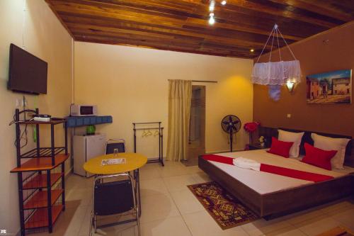 a bedroom with a bed and a television and a table at Hotel National Ambilobe in Ambilobe