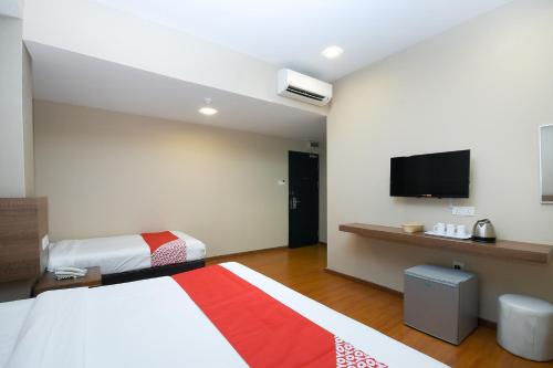 a hotel room with two beds and a flat screen tv at Super OYO 977 Hong Kong Suites in Miri