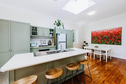 a kitchen with a sink and a counter with stools at The Birdhouse - Your Well-deserved Country Retreat in Mudgee