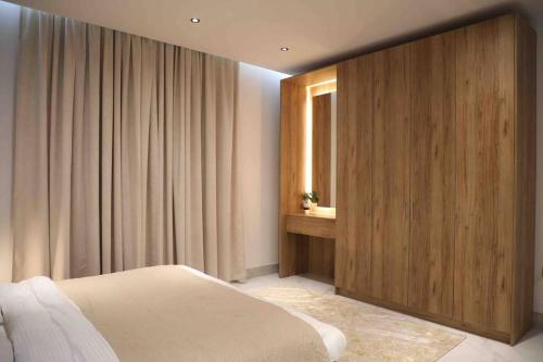 um quarto com uma cama e uma parede de madeira em Cloud Villa Salalah em Salalah