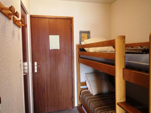 Cette chambre comprend 2 lits superposés et une porte. dans l'établissement Studio cabine 4 pers, pieds des pistes, proche commerces, balcon, vue sur montagnes - FR-1-297-30, à Auris