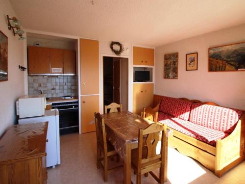 Il dispose d'une cuisine et d'un salon avec un canapé et une table. dans l'établissement Studio cabine 4 pers, 300m des pistes, balcon, parking, animaux ok - Auris en Oisans - FR-1-297-25, à Auris