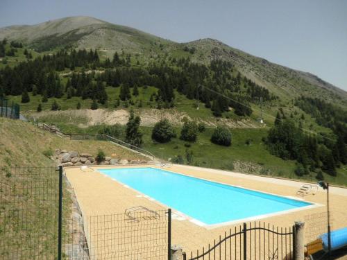 ein großer Pool vor einem Berg in der Unterkunft Appartement Auris, 2 pièces, 3 personnes - FR-1-297-40 in Auris